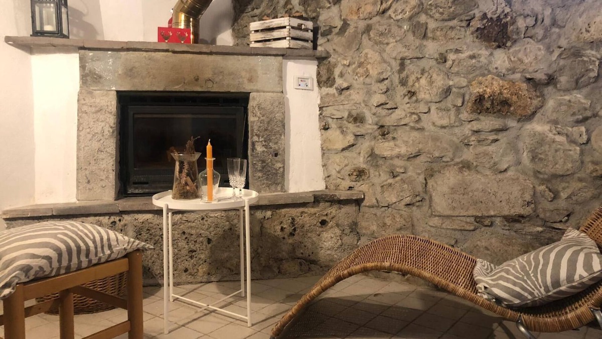 Raveo House | Rustic apartment with beams and stone.