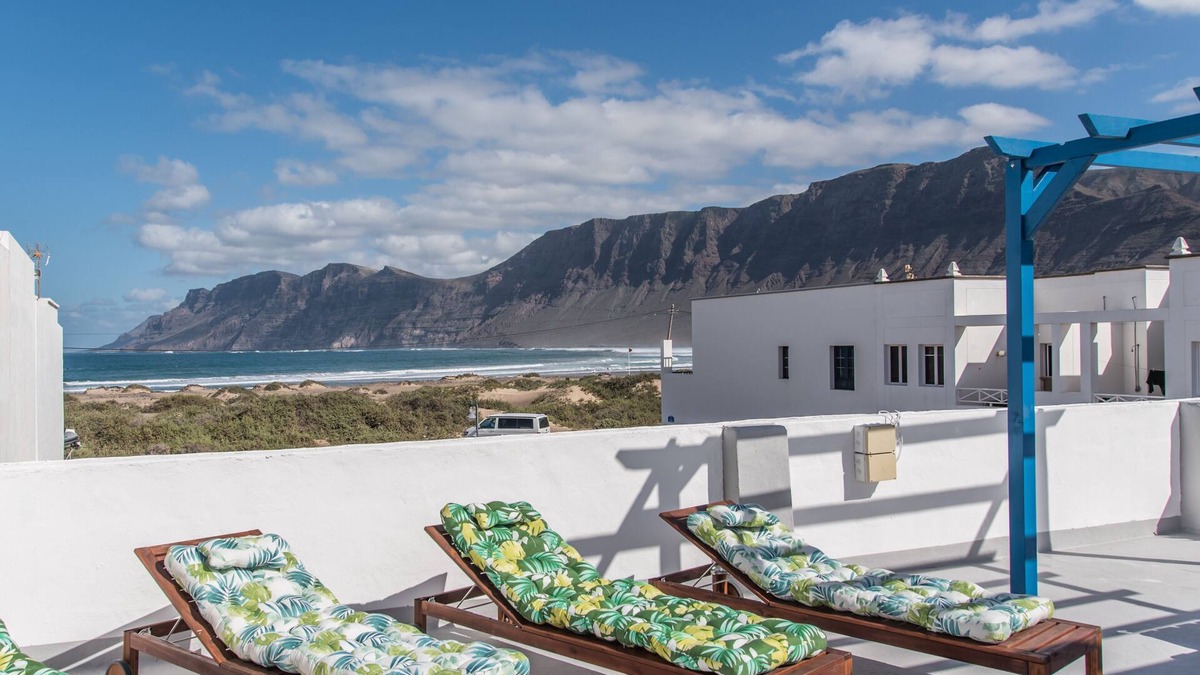 Caleta de Famara Apartment | Sandy Bay Home with roof terrace and sea views