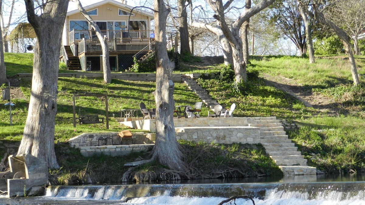 New Braunfels House | Scenic riverfront home on quiet stretch of Guadalupe - waterfall by huge front porch