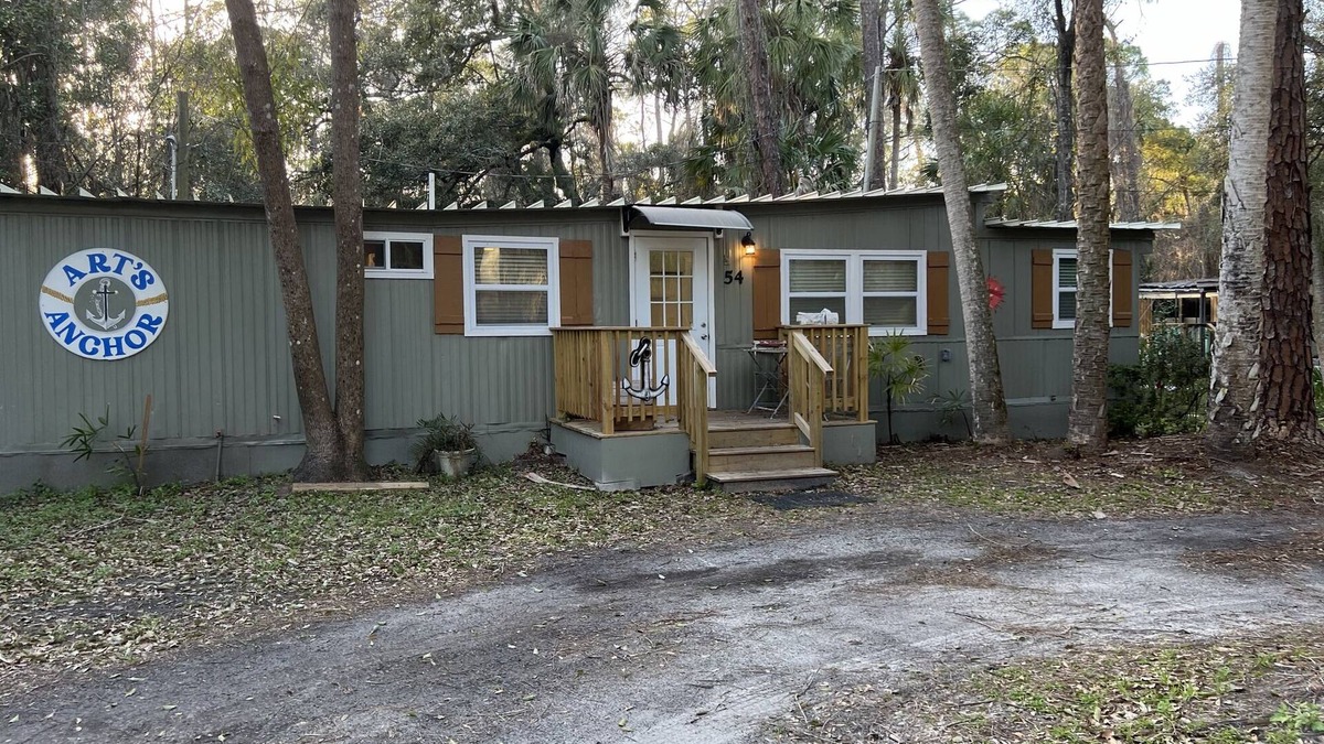 Inglis Apartment | Step into this cozy 2-bedroom cabin nestled in the tranquil woods. The main living area offers comfy seating, including a pull-out futon for additional sleeping space. An efficiency kitchen awaits your culinary adventures, equipped with essentials fo