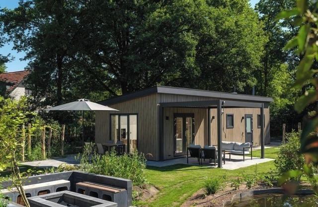 Enjoy a luxurious holiday home for 4 people in the wooded nature of the Veluwe, complete with modern amenities, air conditioning, and a stylish pergola for ultimate comfort. You can also completely unwind in the wonderful private hot tub and sauna, p