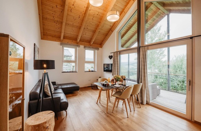 Ferienchalet mit überdachter Veranda mit Lounge Möbel und Schwebeliege.