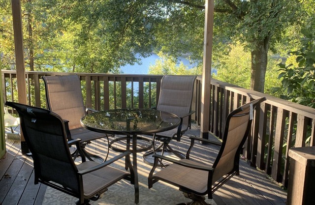 Lakeside house with fireplace, deck, and a fenced backyard with firepit.