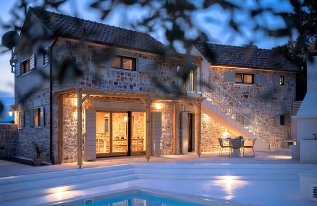 Modern expression of a traditional Hvar stone house amidst sunny nature.