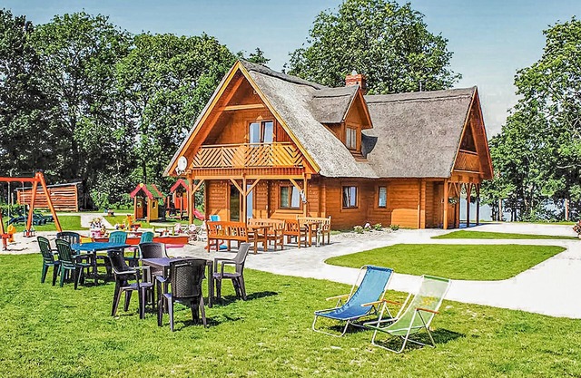 This beautiful, well-maintained wooden house is located on a large, fenced lot.