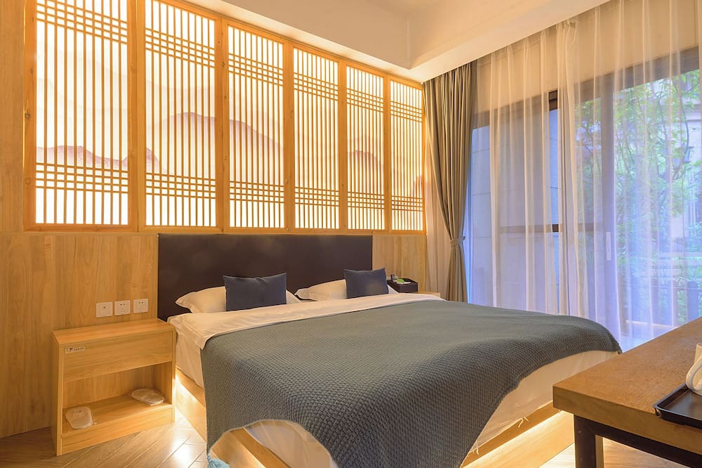 Emeishan House | Heinemann Hotel courtyard or terrace king room B208— with a jacuzzi and a local