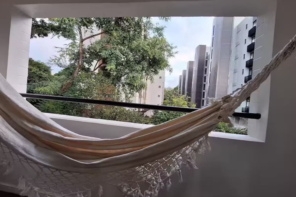 Asa Norte Apartment | Studio Tipuana hammock on the open balcony